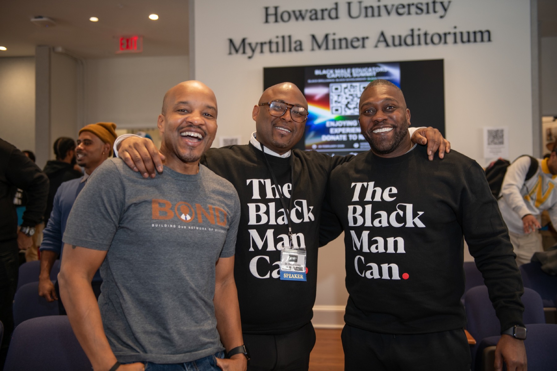 Educators laughing together outside Howard University's Myrtilla Miner Auditorium